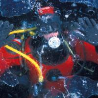 Le lac Sainte-Anne à 2415 m dans le Queyras. Un trou permet de passer sous la fine couche de glace formée dans la nuit pour faire cette image du plongeur - Hautes-Alpes – France